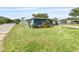 Corner lot showcasing a blue home with fresh landscaping and a green, lush lawn at 4238 Glissade Dr, New Port Richey, FL 34652