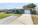 Inviting exterior of a blue home with a concrete driveway and manicured front yard at 4238 Glissade Dr, New Port Richey, FL 34652
