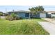 Charming blue home featuring a well-manicured lawn, mature plants, and a single-car garage at 4238 Glissade Dr, New Port Richey, FL 34652