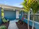 Close-up of a home's front entrance, showing the white door, tropical plants, and exterior details at 4238 Glissade Dr, New Port Richey, FL 34652