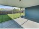 Covered outdoor patio with a view of the fenced in yard and artificial grass at 4238 Glissade Dr, New Port Richey, FL 34652