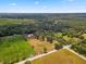 Wide aerial view of country estate featuring lush landscaping, fields and surrounding mature trees at 495 Appaloosa Rd, Tarpon Springs, FL 34688