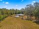 Aerial view of beautiful estate with a long drive, pasture, and mature landscaping at 495 Appaloosa Rd, Tarpon Springs, FL 34688