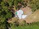 Aerial view of a home with a backyard pool surrounded by lush trees at 495 Appaloosa Rd, Tarpon Springs, FL 34688