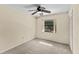 Bright bedroom with a ceiling fan, window, and neutral carpet, creating a comfortable space at 495 Appaloosa Rd, Tarpon Springs, FL 34688