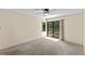 Bedroom featuring carpet, ceiling fan and sliding door access to a screened-in pool and spa at 495 Appaloosa Rd, Tarpon Springs, FL 34688