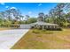 Charming home with a unique roofline, attached garage, and a beautiful flower garden at 495 Appaloosa Rd, Tarpon Springs, FL 34688