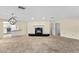 Spacious living room with a modern fireplace, tile floors, and a chandelier at 495 Appaloosa Rd, Tarpon Springs, FL 34688