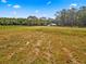 Large grassy pasture enclosed by a dark wooden fence with distant white canopy at 495 Appaloosa Rd, Tarpon Springs, FL 34688