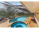 Beautiful screened-in pool and spa with a rock feature and a spacious deck surrounded by trees at 495 Appaloosa Rd, Tarpon Springs, FL 34688