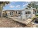 Backyard featuring a wooden deck with table and chairs on a partly overgrown lawn at 504 Casas Bonitas Dr, Nokomis, FL 34275