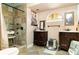 Bathroom with tiled shower, dual vanities, and neutral decor creates a serene spa-like retreat at 504 Casas Bonitas Dr, Nokomis, FL 34275