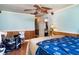 Cozy bedroom features wood-paneled walls, a ceiling fan and a view into another room at 504 Casas Bonitas Dr, Nokomis, FL 34275
