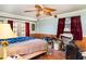 Bedroom with a unique ceiling fan, wood-paneling, and natural light from the windows and door at 504 Casas Bonitas Dr, Nokomis, FL 34275