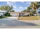 Charming single-story home featuring an attached garage, manicured lawn, and mature trees at 504 Casas Bonitas Dr, Nokomis, FL 34275