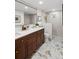 Bright bathroom features double sinks, a large mirror, a tiled shower, and gold fixtures at 5707 N Branch Ave, Tampa, FL 33604