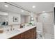 Bright bathroom features double sinks, a large mirror, a tiled shower, and gold fixtures at 5707 N Branch Ave, Tampa, FL 33604