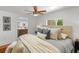 Comfortable bedroom features a ceiling fan, a large bed, and an ensuite bathroom for added convenience at 5707 N Branch Ave, Tampa, FL 33604
