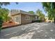 A detached house featuring a private driveway, wooden deck, and inviting French doors surrounded by lush greenery at 5707 N Branch Ave, Tampa, FL 33604