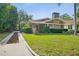 Charming home with well-maintained landscaping, including a lush lawn, mature trees and an inviting entrance at 5707 N Branch Ave, Tampa, FL 33604
