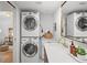 Laundry room features a stacked washer and dryer, a sink, and a large mirror at 5707 N Branch Ave, Tampa, FL 33604