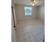 A neutral-toned bedroom with tiled floors and natural light from a window and a ceiling fan at 6315 Shoreline Dr # 3107, St Petersburg, FL 33708