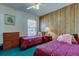 Bedroom featuring wood paneled accent wall, ceiling fan, and two twin beds at 6421 Wilshire Dr, Tampa, FL 33615