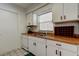 Bright kitchen features neutral white cabinetry, wood countertops and tile floors at 6421 Wilshire Dr, Tampa, FL 33615
