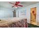 Bright main bedroom boasts a red ceiling fan and adjacent bathroom at 6421 Wilshire Dr, Tampa, FL 33615