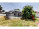View of the screened pool and patio with tropical foliage from the backyard at 6421 Wilshire Dr, Tampa, FL 33615
