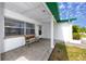 Charming front porch has brick pavers, a bench, and a white column with a green awning at 7020 Sonata Dr, Port Richey, FL 34668