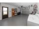 Garage with updated door and access to laundry facilities, storage shelving, and mechanicals at 7020 Sonata Dr, Port Richey, FL 34668