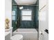 Bathroom featuring decorative green tile and a bathtub with gold fixtures at 708 53Rd N Ave, St Petersburg, FL 33703