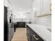 Bright modern kitchen featuring black lower cabinets, white upper cabinets, and stainless steel appliances at 708 53Rd N Ave, St Petersburg, FL 33703