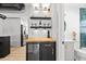 Charming kitchen features a built-in wine cooler and shelving next to a renovated bathroom at 708 53Rd N Ave, St Petersburg, FL 33703