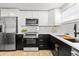 Modern kitchen with stainless steel appliances, black and white cabinets, and ample counter space at 708 53Rd N Ave, St Petersburg, FL 33703