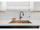Close-up of a stylish kitchen sink with matte black faucet, white countertop, and subway tile backsplash at 708 53Rd N Ave, St Petersburg, FL 33703