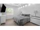 Bedroom with gray bedding, decorative wall panel and pendant lighting at 7130 102Nd Ln, Seminole, FL 33772