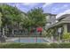 View of community pool in front of condo building with lush landscaping and a visitor's parking sign at 7130 102Nd Ln, Seminole, FL 33772