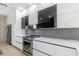 Modern kitchen featuring sleek white cabinets, stainless steel appliances, and light marble countertops at 7130 102Nd Ln, Seminole, FL 33772
