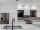 Modern kitchen featuring sleek white cabinets, stainless steel appliances, and a black faucet at 7130 102Nd Ln, Seminole, FL 33772