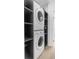 Convenient laundry area featuring a stacked washer and dryer set, with gray shelving storage at 7130 102Nd Ln, Seminole, FL 33772