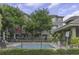 Community pool surrounded by lush landscaping, iron fencing and shaded seating areas at 7130 102Nd Ln, Seminole, FL 33772
