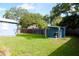 Large backyard with green grass, shed for storage, and mature trees adding privacy at 731 20Th Nw St, Largo, FL 33770