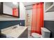 Traditional bathroom showcasing neutral colors, classic fixtures, and a bright orange shower curtain at 731 20Th Nw St, Largo, FL 33770
