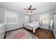 A cozy bedroom features a decorative rug, a ceiling fan, and natural light from two windows at 731 20Th Nw St, Largo, FL 33770