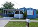 Charming blue home with covered parking and a well-manicured lawn and a small mailbox at 731 20Th Nw St, Largo, FL 33770
