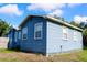 Side view of home showcasing the classic architecture, blue siding, trimmed windows, and well-kept landscaping at 731 20Th Nw St, Largo, FL 33770