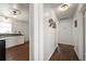 Hallway view of the kitchen with white cabinets, tile backsplash, and hardwood floors at 731 20Th Nw St, Largo, FL 33770