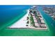 Stunning aerial view of beachfront condos with turquoise waters and white sand beach at 7564 Bayshore Dr # 302, Treasure Island, FL 33706